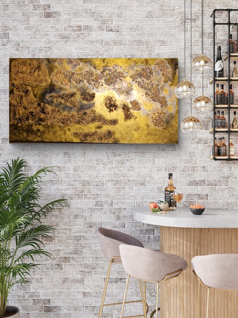 Erdgold – breitformatiges Bild in Ocker, Rost und Gold mit tiefer Reliefstruktur – an der Wand im Raum